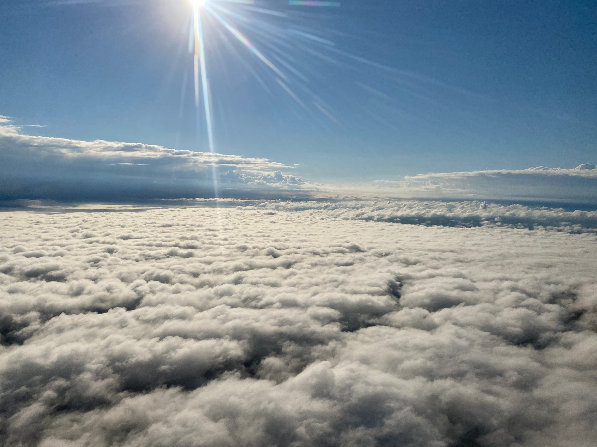 Sonnendurchflutetes Wolkenmeer aus dem Cockpit